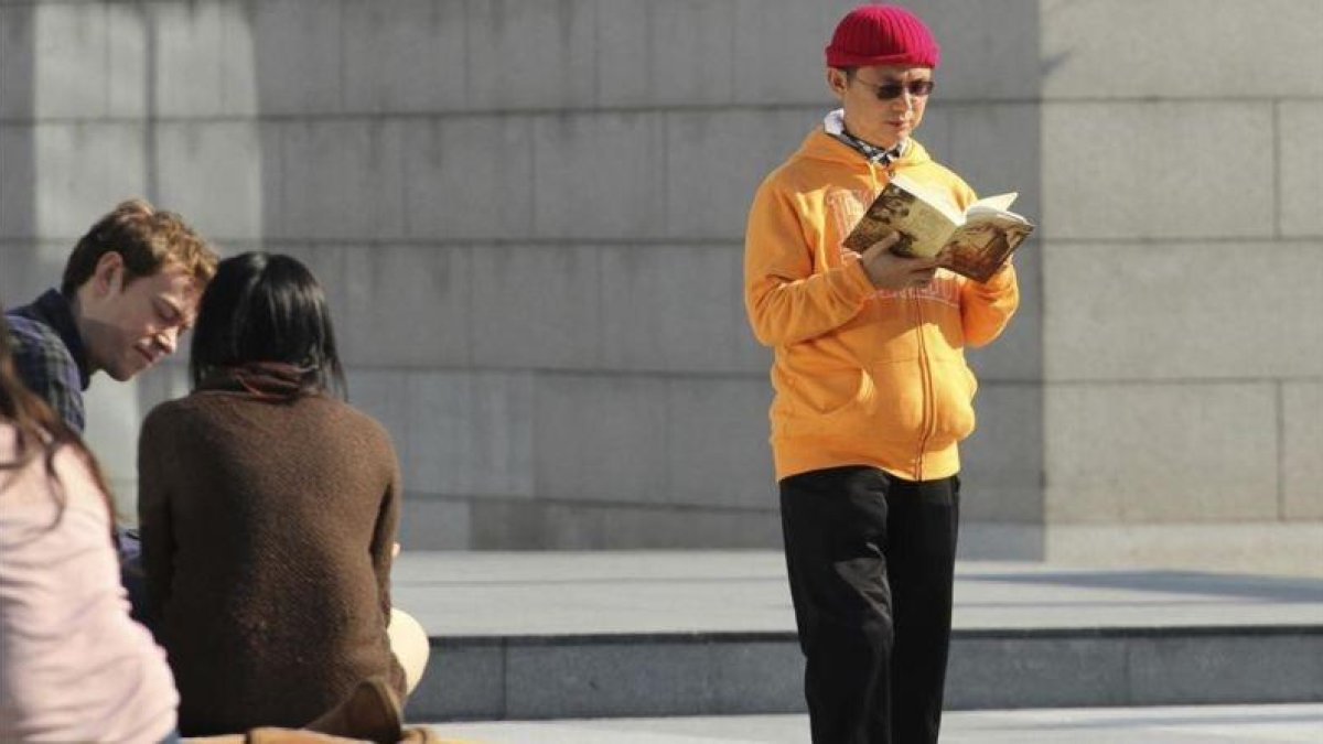 El millonario desaparecido Xiao Jianhua lee un linbro en centro financiero de Hong Kong en diciembre del 2013.-AP