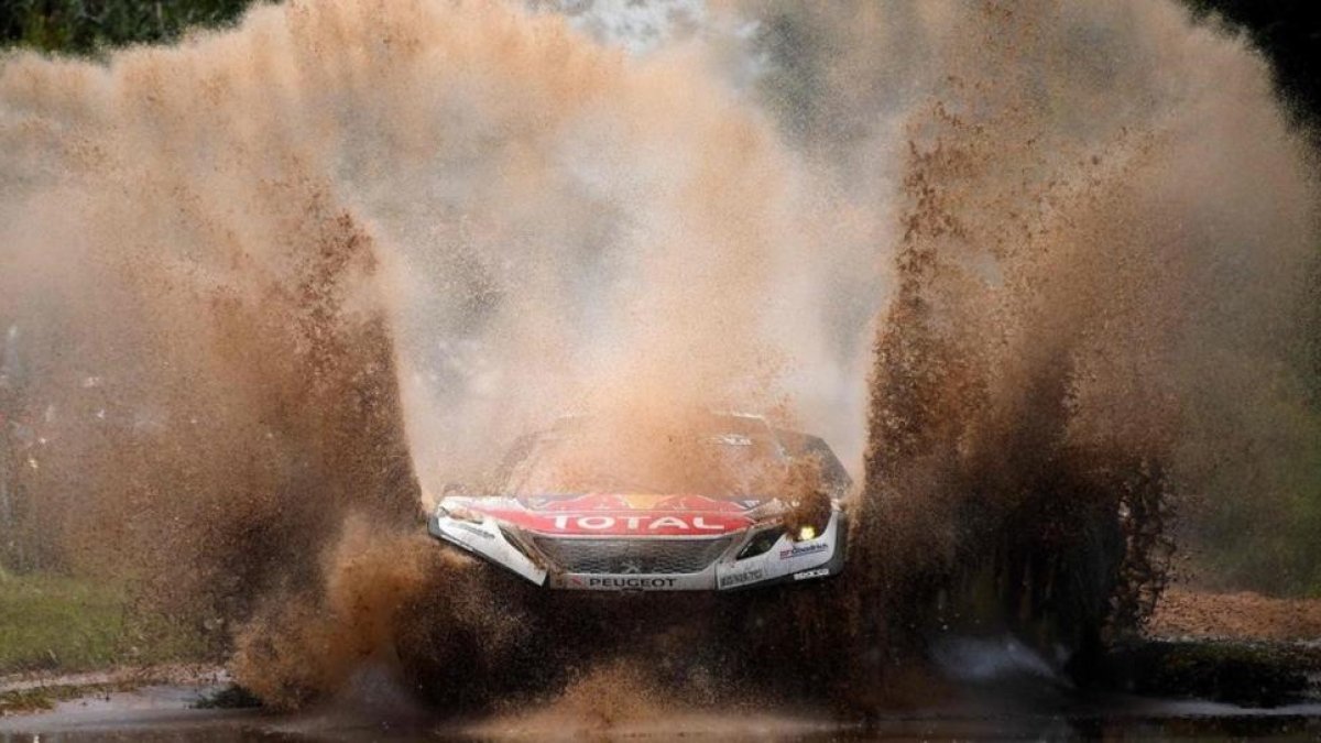 Sebastien Loeb (Peugeot) atraviesa un charco en la etapa de hoy del Dakar.-AFP / FRANK FIFE