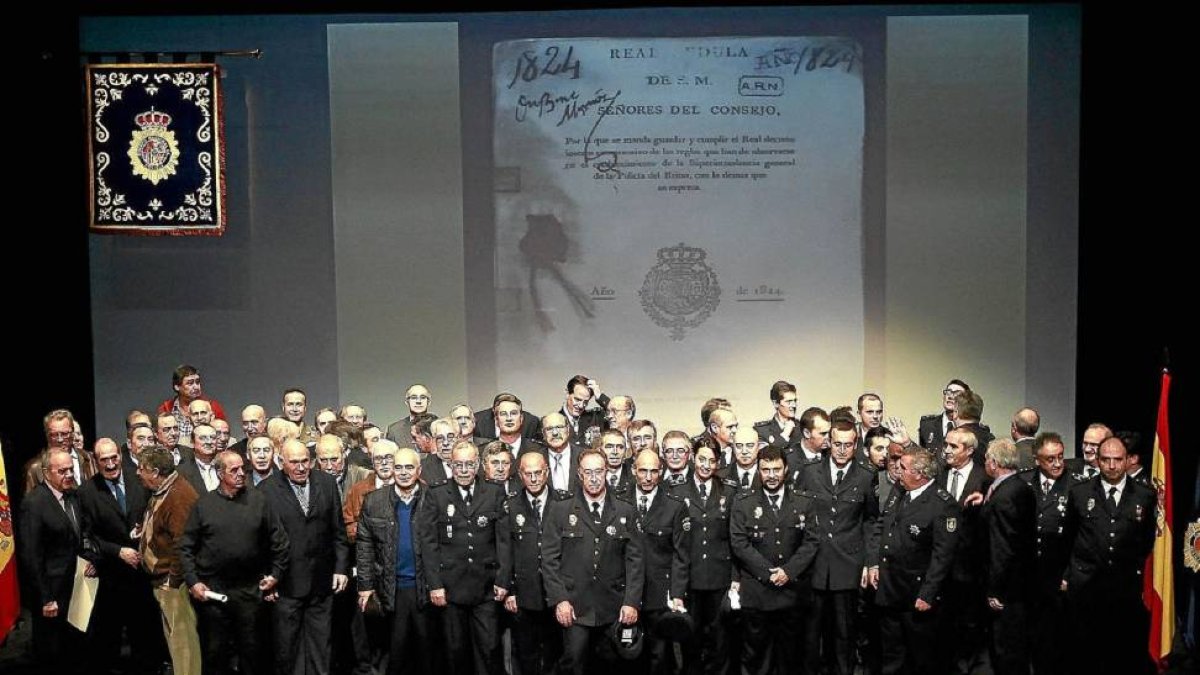 Foto de familia de los policías distinguidos con diplomas, medallas, cruces, encomiendas y placas en el escenario del teatro Zorrilla-J.M.Lostau