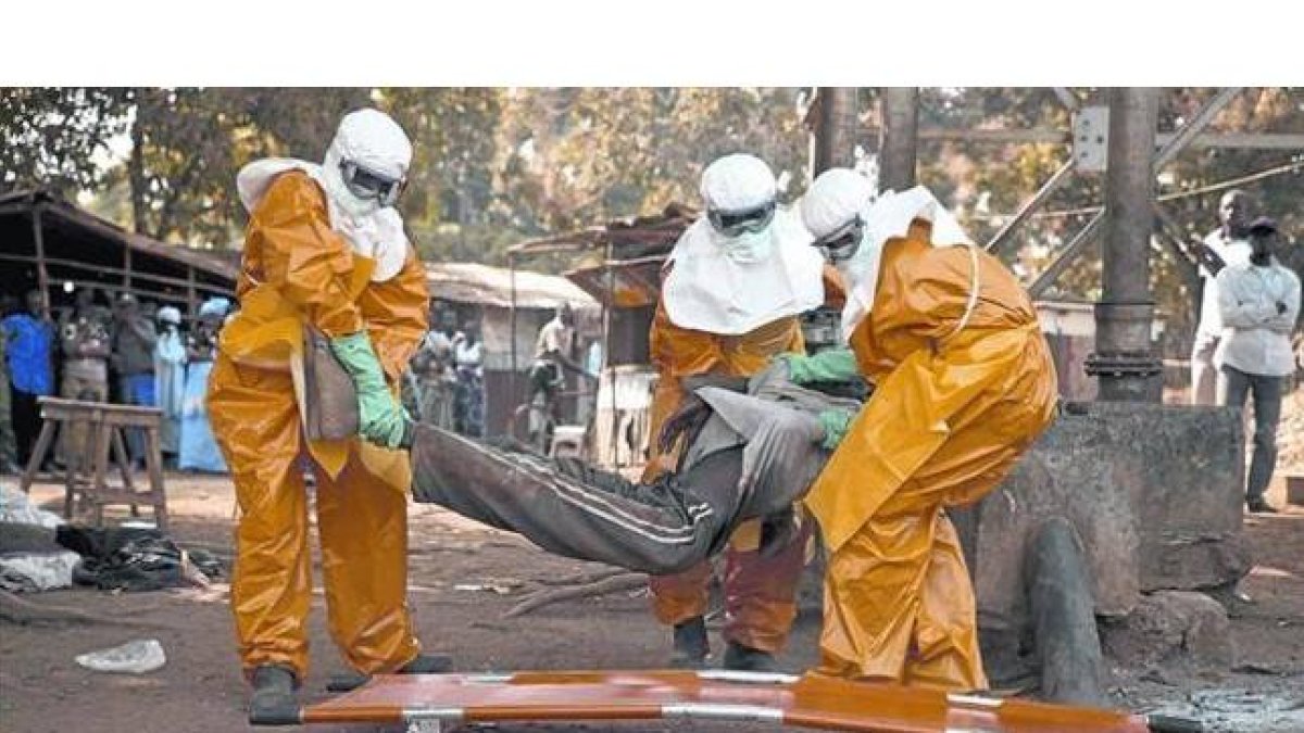 Sanitarios de la OMS retiran el cadáver de un enfermo de ébola en Guinea, el pasado enero.-Foto: REUTERS / MISHA HUSSAIN