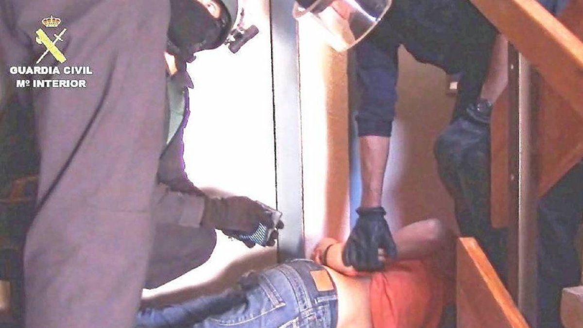 Guardias Civiles inmovilizan a uno de los detenidos en un piso de la calle Hermanos Cossío de Huerta del Rey.-E.M