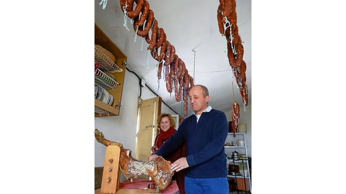 María José observa a su cuñado José Alberto mientras corta jamón.-J.M. LOSTAU