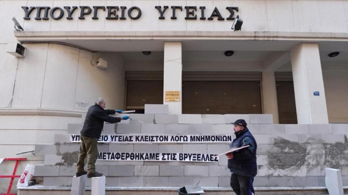 Manifestantes levantan un muro en la sede del Ministerio de Sanidad de Grecia con la inscripción 'Cerrado por el rescate. Hemos sido trasladados a Bruselas', en una protesta contra la austeridad en Atenas, en diciembre del 2016.-LOUISA GOULIAMAKI