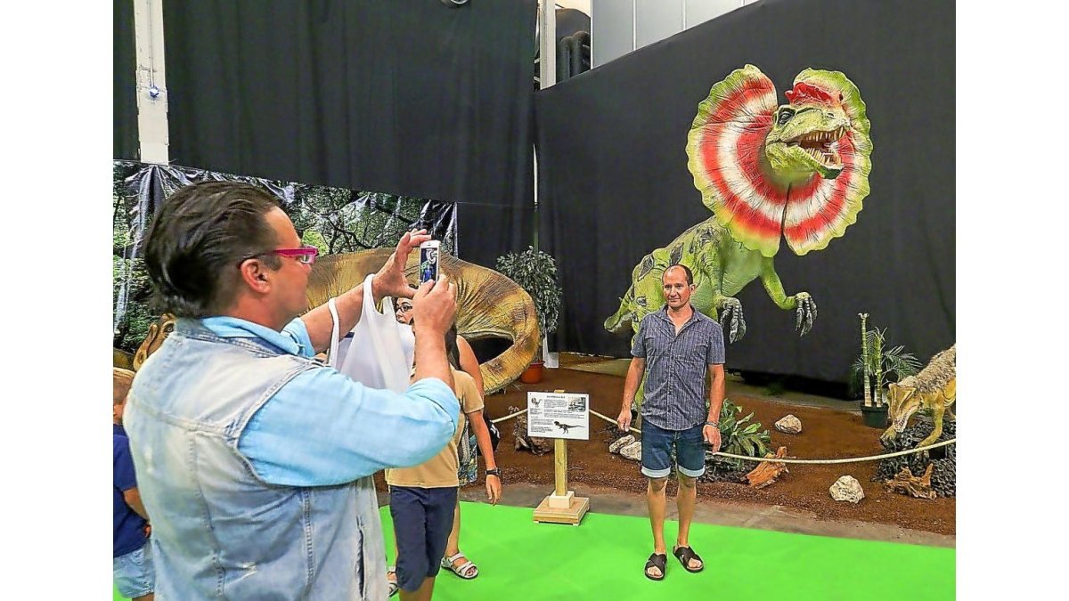 Una persona se fotografía delante de uno de los dinosaurios de la Feria.-R. GRÁFICO: MIGUEL ÁNGEL SANTOS