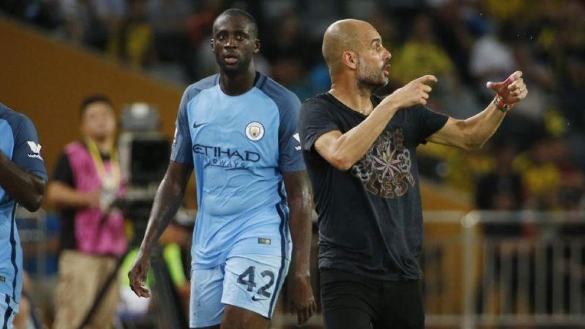 Touré Yaya y Guardiola, en un amistoso que jugó el City ante el Dortmund en China esta pretemporada.-BOBBY YIP