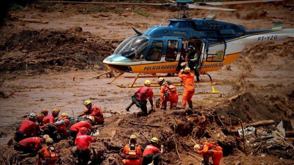 Bomberos rescatan a víctimas tras la ruptura de una presa minera, en Brumadinho (Brasil).-ANTONIO LACERDA (EFE)