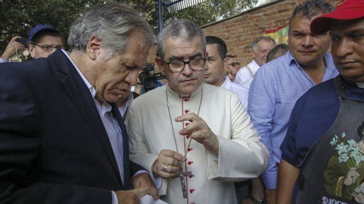 El secretario general de la OEA, Luis Almagro, con el obispo Víctor Ochoa, en un centro para inmigrantes en Cúcuta.-SCHNEYDER MENDOZA (AFP)