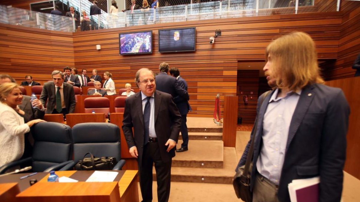 El presidente de la Junta, Juan Vicente Herrera, conversa con el portavoz de Podemos, Pablo Fernández, en el debate del estado de la Comunidad.-ICAL