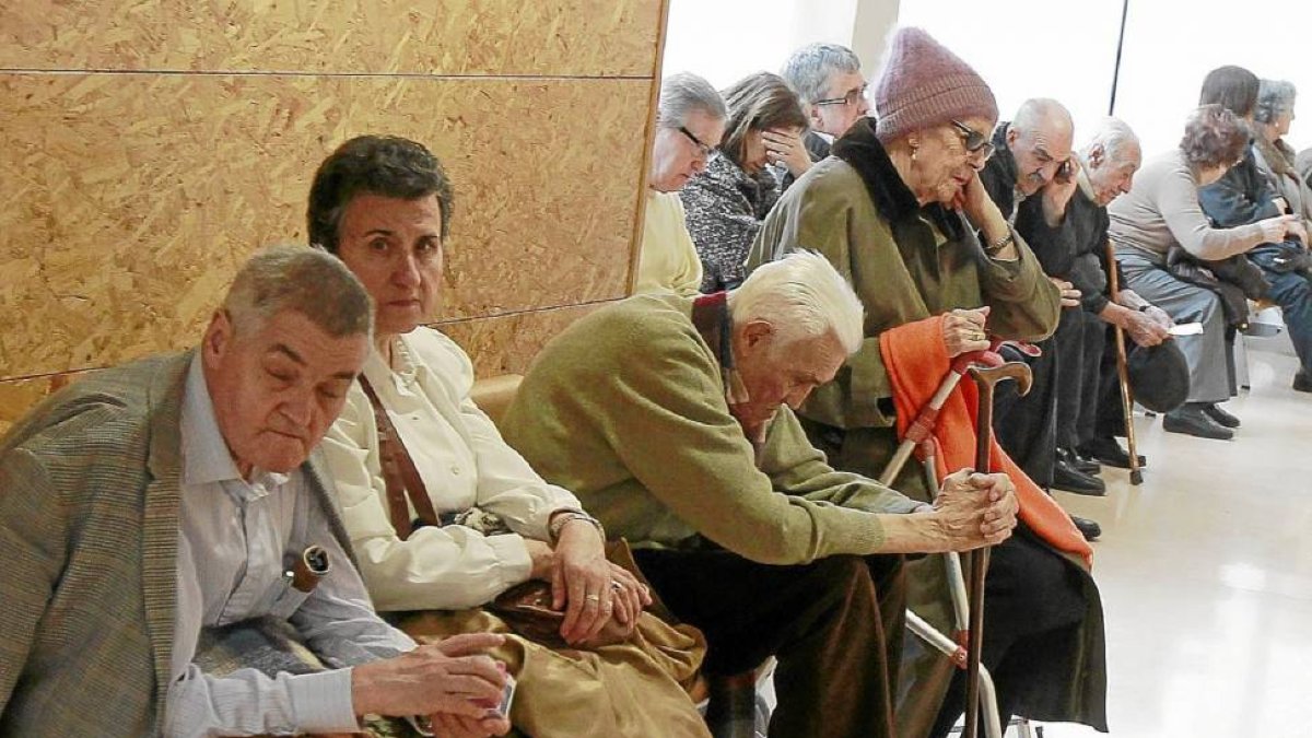 Decenas de personas, en gran parte mayores, esperan pacientes a que les toque su turno en una consulta del centro de salud de Plaza del Ejército-J.M.Lostau