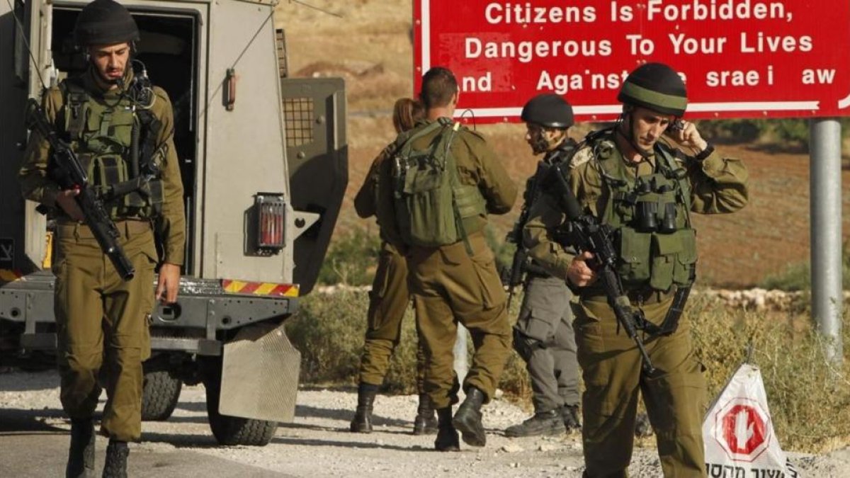 Soldados israelís a la entrada de una localidad palestina de Yatta, de donde salieron los dos atacantes.-AFP HAZEM BADER