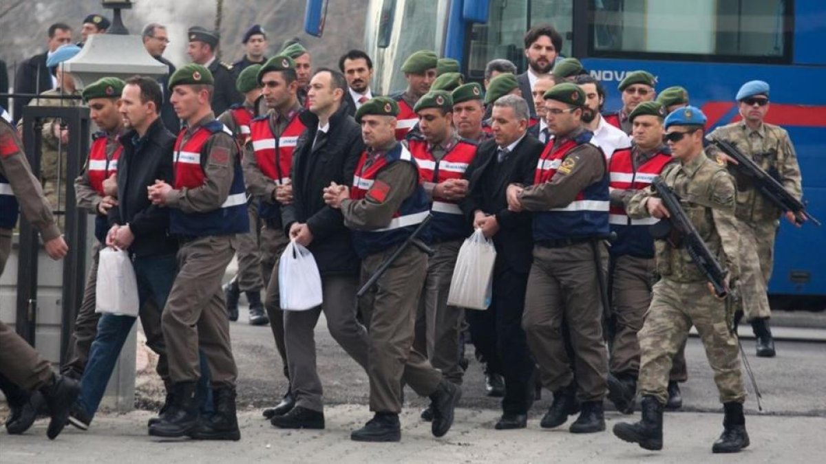 La Cámara de Comercio de la localidad suroccidental turca de Mugla amaneció este lunes lindada. Ha sido la sede elegida para juzgar a 47 acusados de estar involucrados en el intento de captura y asesinato del presidente turco, Recep Tayyip Erdogan, ya que-Llegada de algunos de los militares acusados al juicio en Mugla.