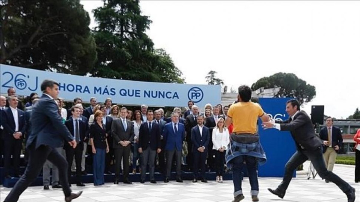 Un joven protesta durante la presentación de los candidatos del PP al Congreso de los Diputados.-DAVID CASTRO