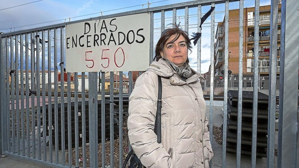 La presidenta de la Asociación de Vecinos Pilarica, Margarita García, posa junto al cartel que recuerda a los vecinos del barrio los días que llevan separados.-J. M. LOSTAU