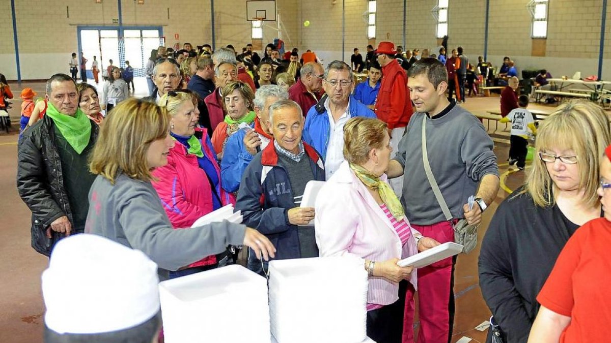 Peñistas hacen cola en el polideportivo municipal para recibir su ración de ‘comida solidaria’-Marta Fernández