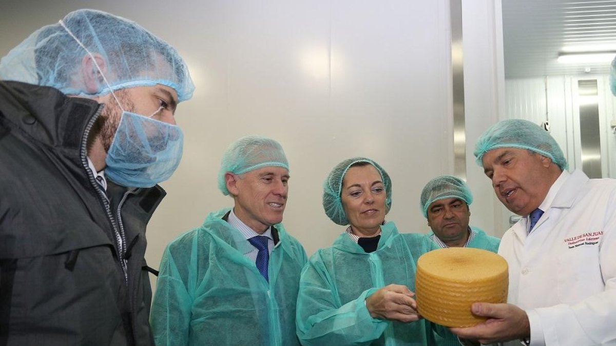 Milagros Marcos; junto a los propietarios Juan Manuel Rodríguez (D), y su hijo Sergio (I), entre otros, en la visita a las instalaciones de la empresa quesera Valle de San Juan, en Palencia.-ICAL