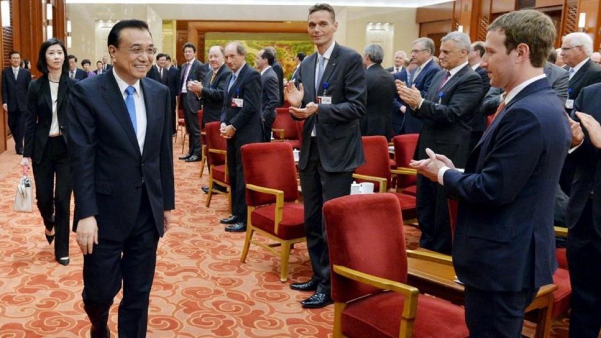 Zuckerberg (derecha) aplaude a la llegada del primer ministro chino, Li Keqiang, en una reunión empresarial en Pekín, el 21 de marzo.-REUTERS / KENZABURO FUKUHARA