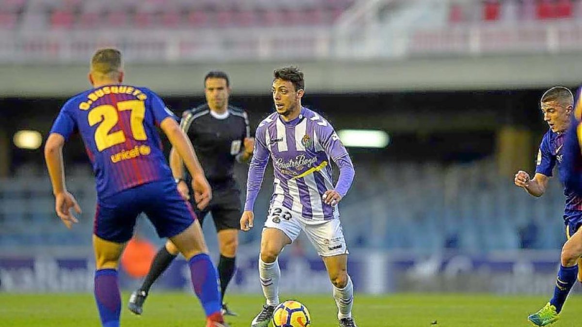 Óscar Plano busca un compañero para darle un pase, ante la vigilancia del azulgrana Busquets.-PHOTO-DEPORTE