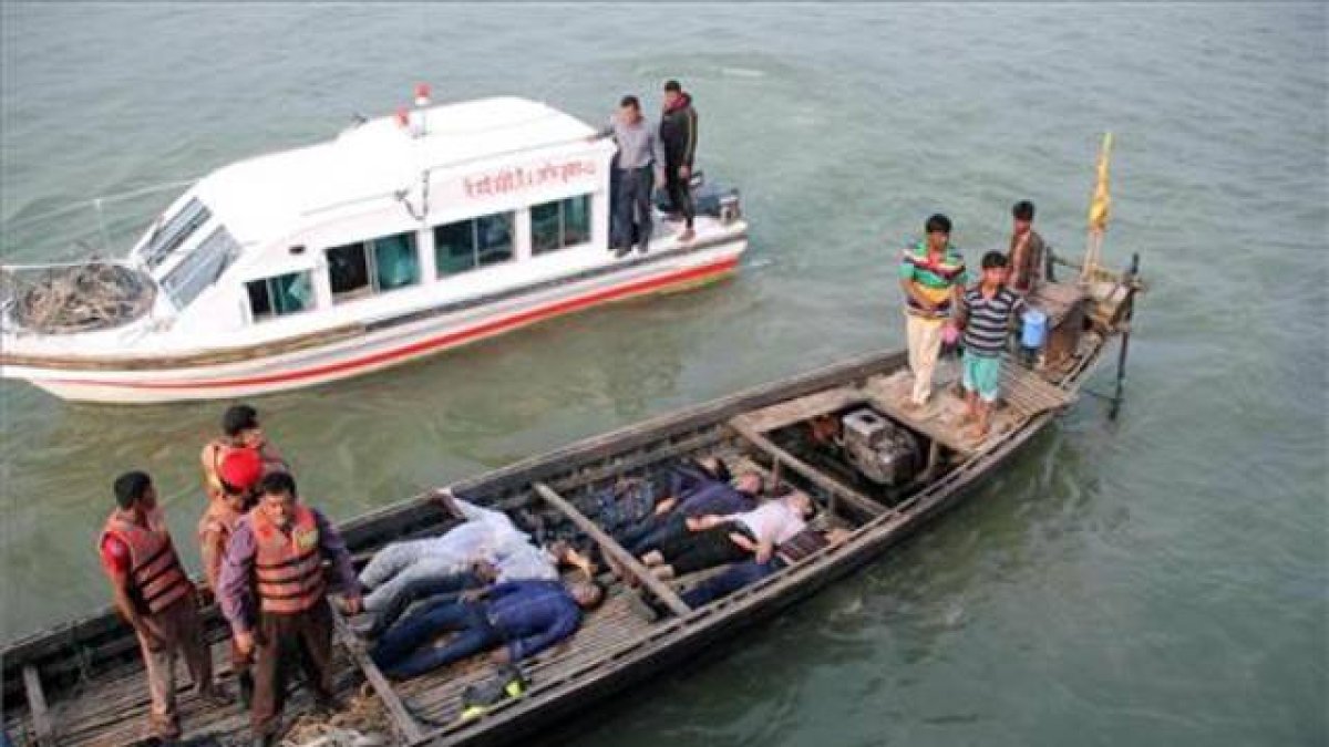 Los equipos de emergencia, rescatan a pasajeros del ferri, tras la colisión, este domingo, en el río Padma, en Bangladesh.-Foto: AFP