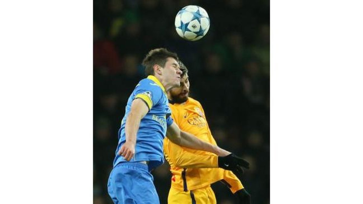 Gerard Piqué y Vitali Gayduchik intentan cabecear un balón, en el Bate-Barça.-AGP / MAXIM MALINOVSKY