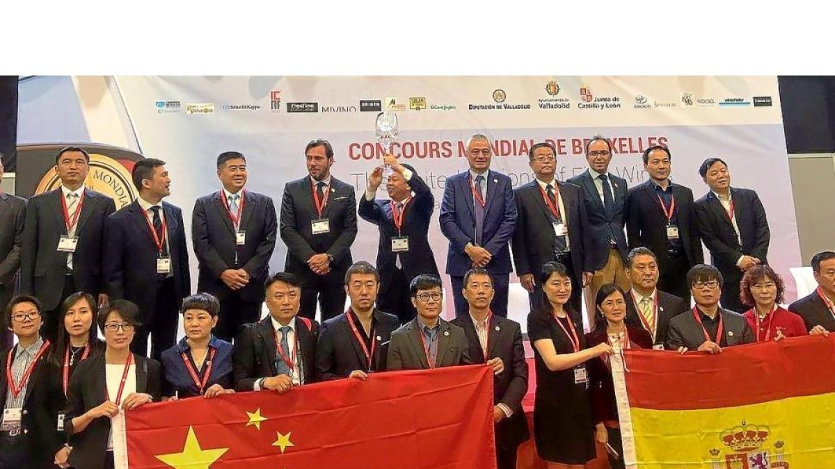 Unión de banderas entre China y España mientras el teniente de alcalde de Haidán alza la gran copa de vino.-E.M.