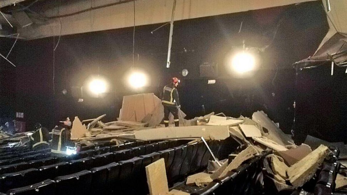 Los bomberos en la sala del derrumbe, con restos del techo sobre sus butacas.-Policía Municipal