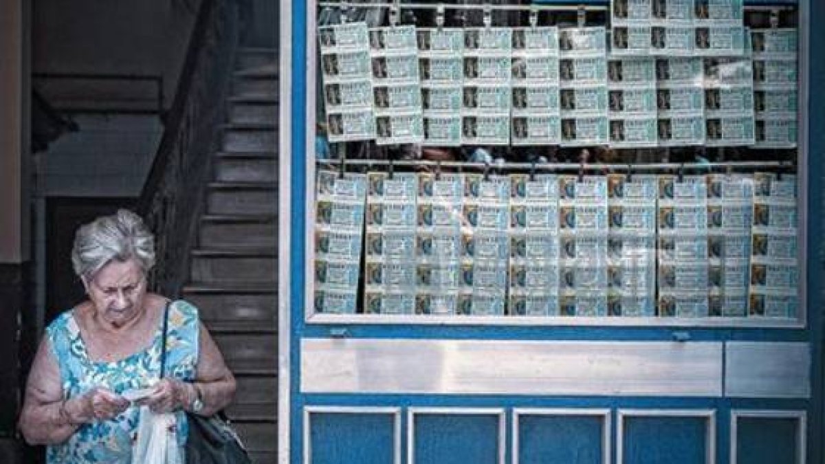 Una mujer sale de una administración de lotería en las Rambles de Barcelona.-Foto: JOAN CORTADELLAS