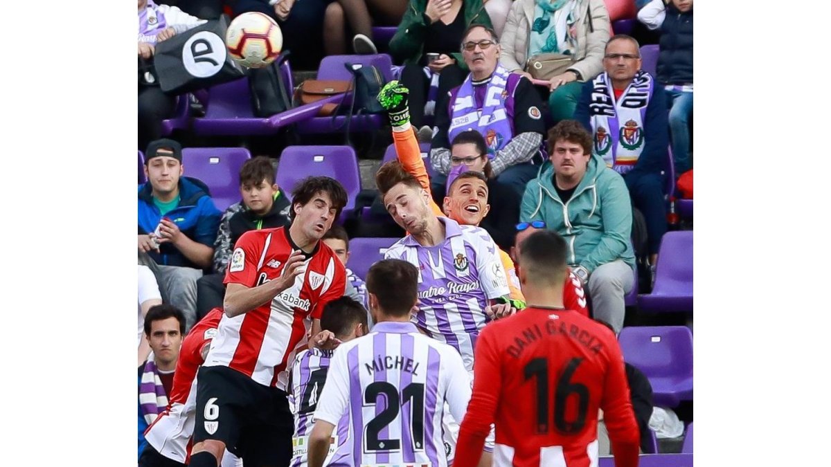 Masip despeja con el puño un centro al área y choca con Calero con San José a su lado.-J.M. LOSTAU