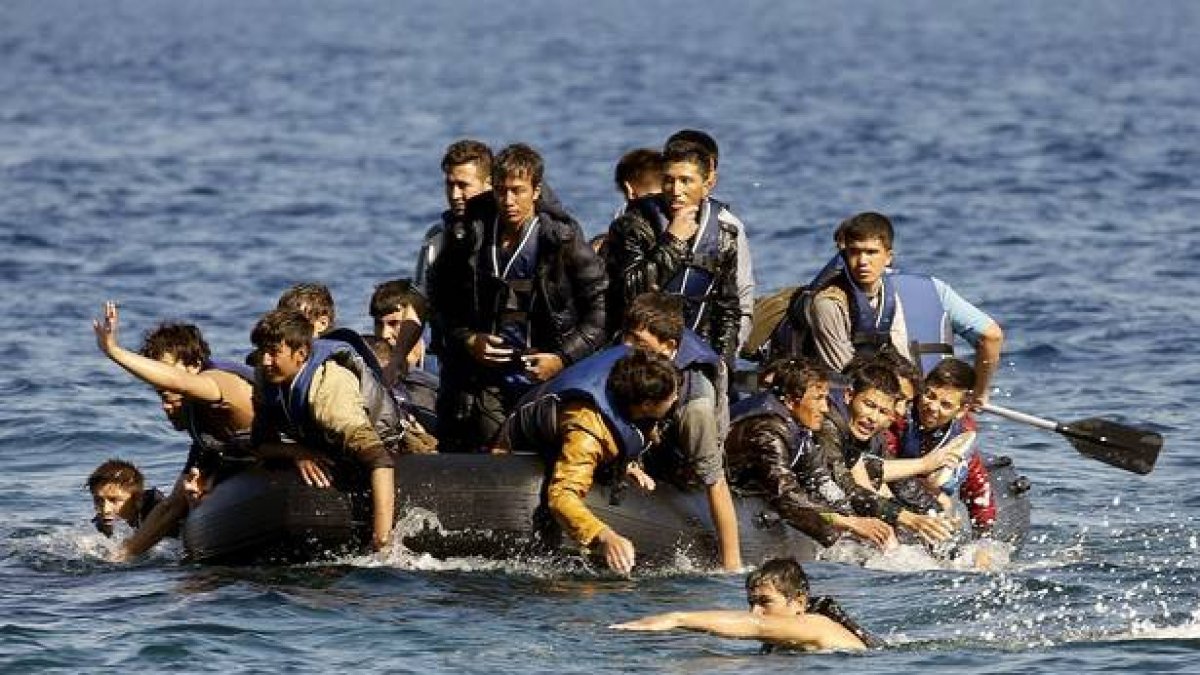 Refugiados de Afganistan ante las costas de Lesbos en una lancha a la deriva.-YANNIS BEHRAKIS / REUTERS