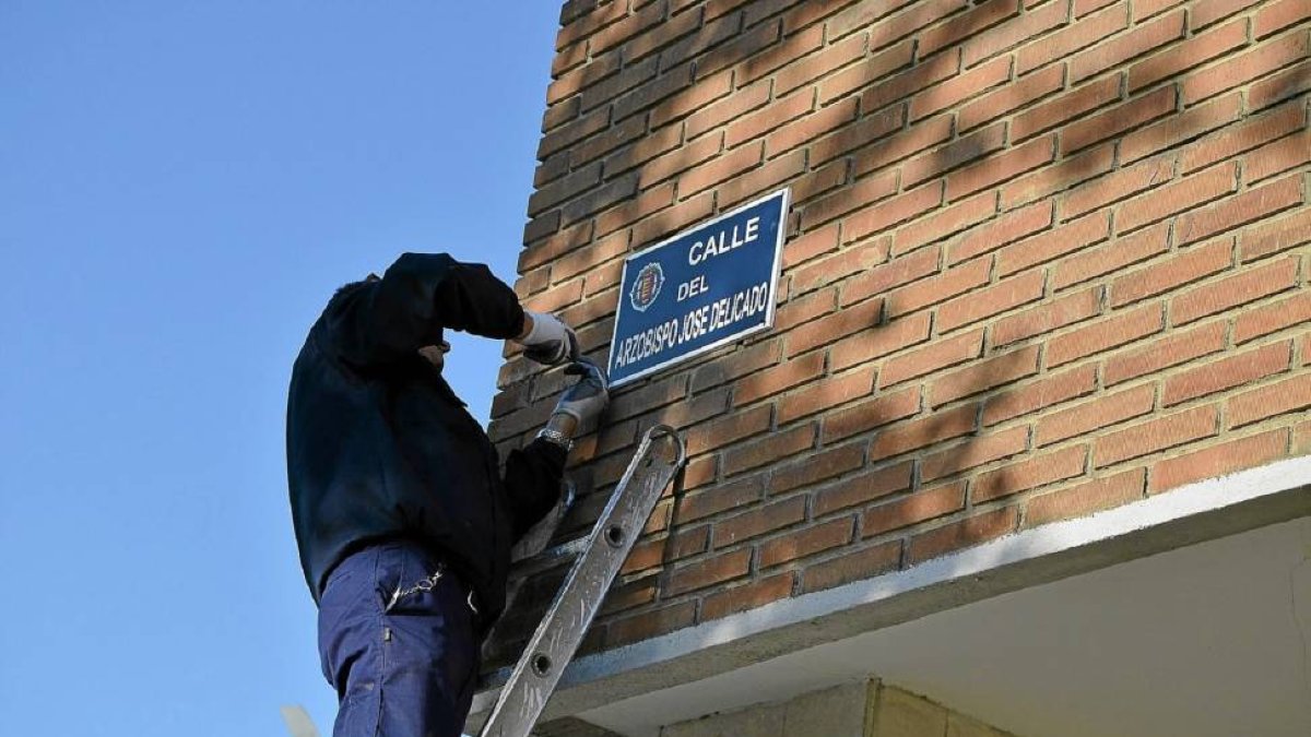 Un operario cambia el nombre de la calle Antonio Lorenzo Hurtado por el de calle Arzobispo José Delicado-Manuel García San José