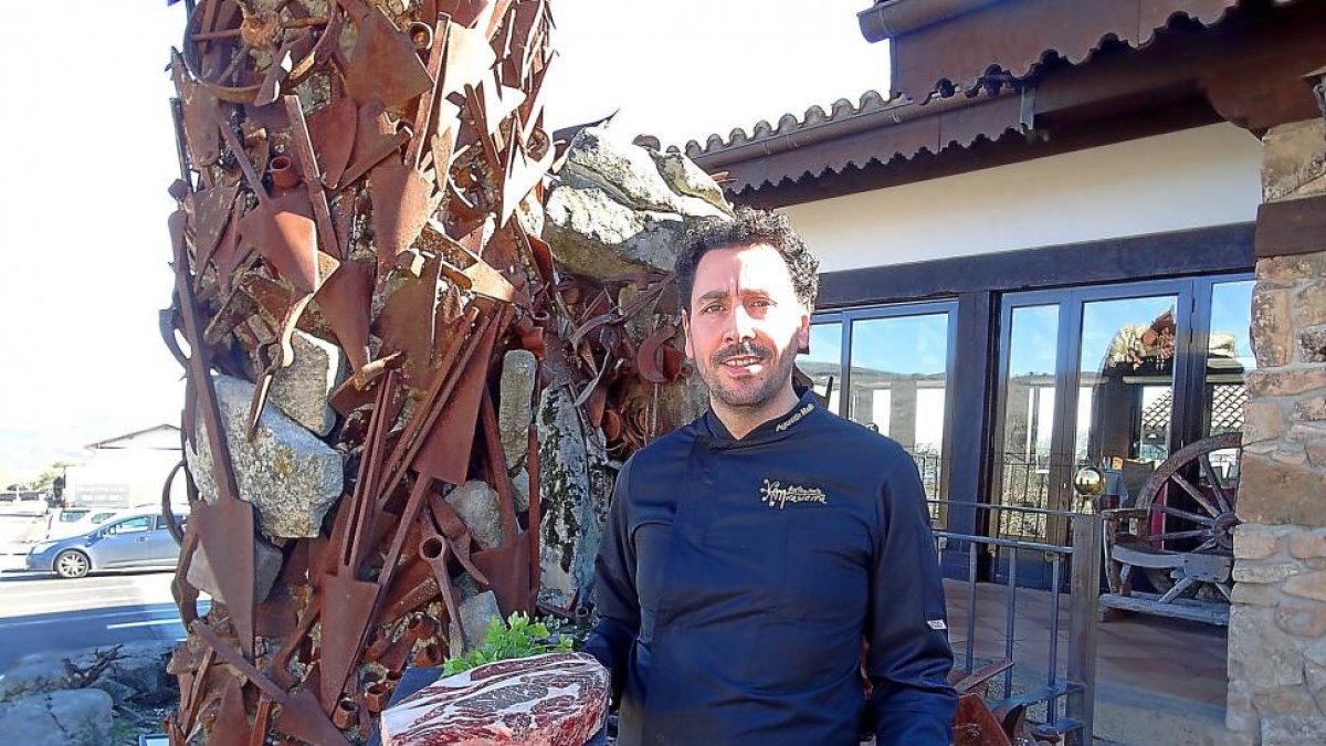 Agustín Maíllo, junto a la escultura ‘Memorias de esta tierra’, con un zorongollo y una chuleta de Morucha.-ARGI