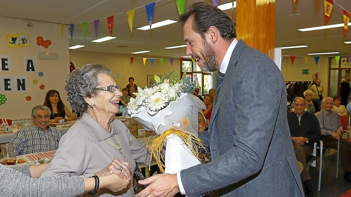 El alcalde, Óscar Puente, entrega el ramo de flores a la homenajeada Carmen González.-J. M. LOSTAU