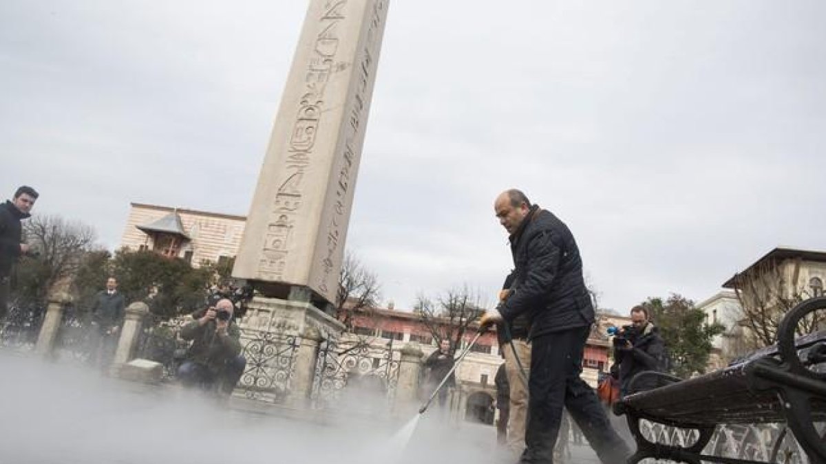 Un operario limpia el escenario del atentado suicida de ayer junto a uno de los obeliscos que se alzan en la explanada de Sultanahmet.-EFE / TOLGA BOZOGLU