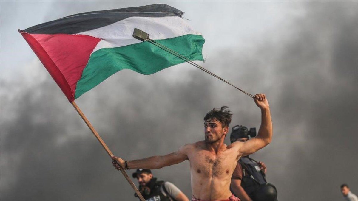 La imagen que se ha convertido en símbolo de la resistencia palestina en Gaza: Aed Abu Amro, con una honda en la mano izquierda y una bandera palestina en la derecha, durante una protesta el 22 de octubre del 2018.-GETTY IMAGES / ANADOLU / MUSTAFA HASSONA