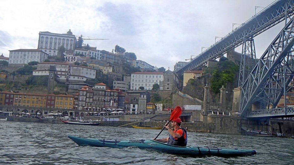Paso de un turista en kayak por la ciudad portuguesa de  Oporto.-J.L.C.