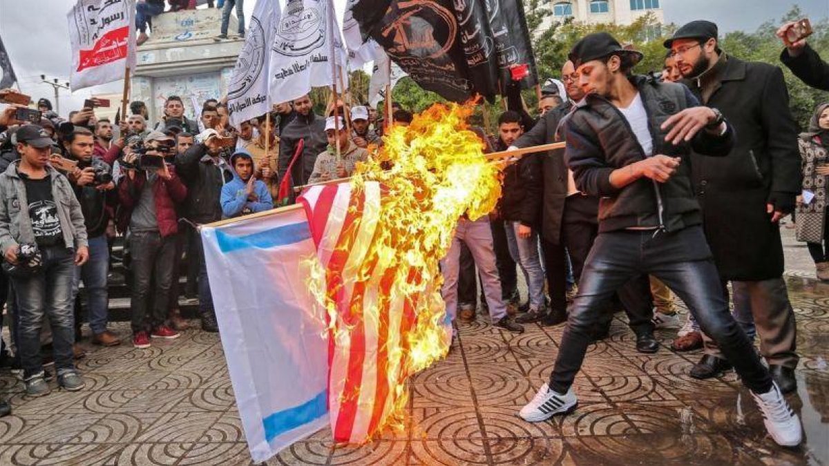 Manifestantes palestinos queman banderas de EEUU e Israel en Gaza.-AFP / MAHMUD HAMS