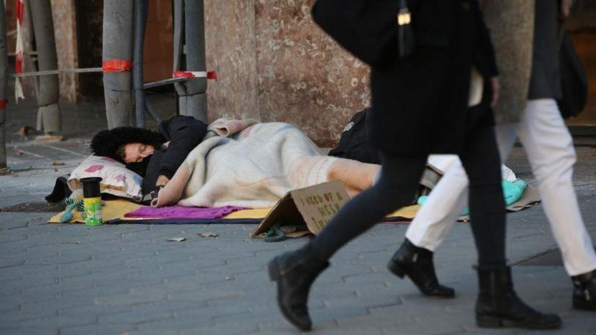 Un hombre duerme en Paseo de Gràcia (Barcelona), el pasado mes de noviembre.-RICARD CUGAT
