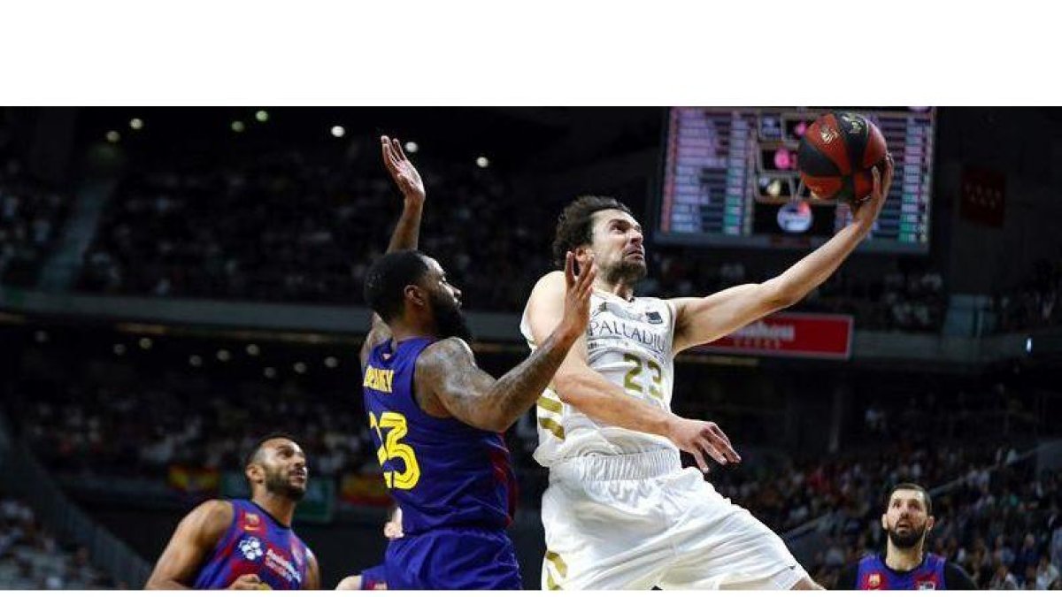 Serbgio Llull entra a canasta defendido por Malcolm Delamey.-EFE / EMILIO NARANJO