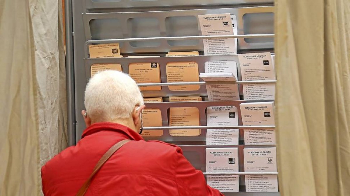 Una mujer busca la papeleta en un colegio electoral, el domingo.-Ical