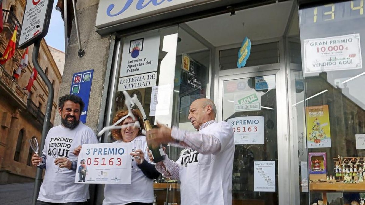 Celebrán con champán el tercer premio de la lotería vendido en la calle San Pablo de Salamanca.-Ical