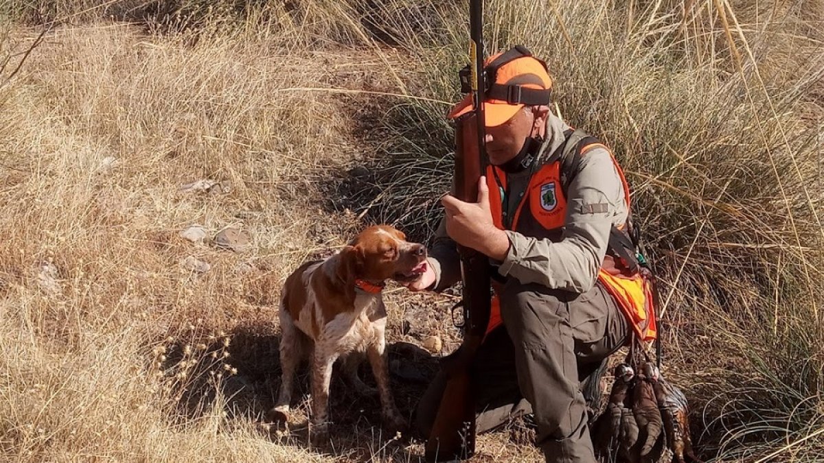Un aficionado que acaba de cobrar una perdiz felicitando a su perro. Leonardo de la Fuente