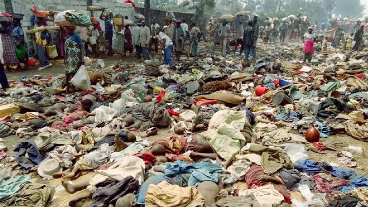 Refugiados ruandeses pasan junto a los cuerpos sin vida de cientos de compatriotas asesinados en la frontera con Zaire el 18 de julio de 1994.-AFP / PASCAL GUYOT