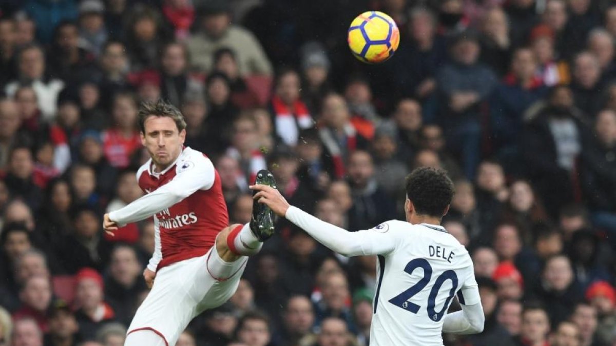 Laurent Koscielny despeja un balón ante la presencia de Dele Alli.-FACUNDO ARRIZABALAGA (EFE)