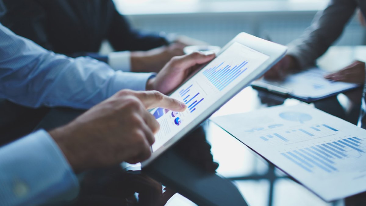 Image of businessperson pointing at document in touchpad at meeting