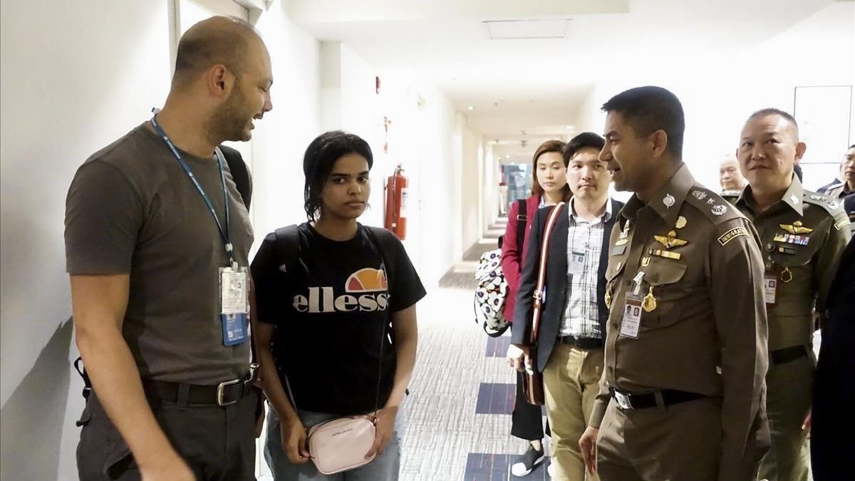 Rahaf, junto a oficiales de inmigración de la ONU en el aeropuerto de Bangkok.-AFP