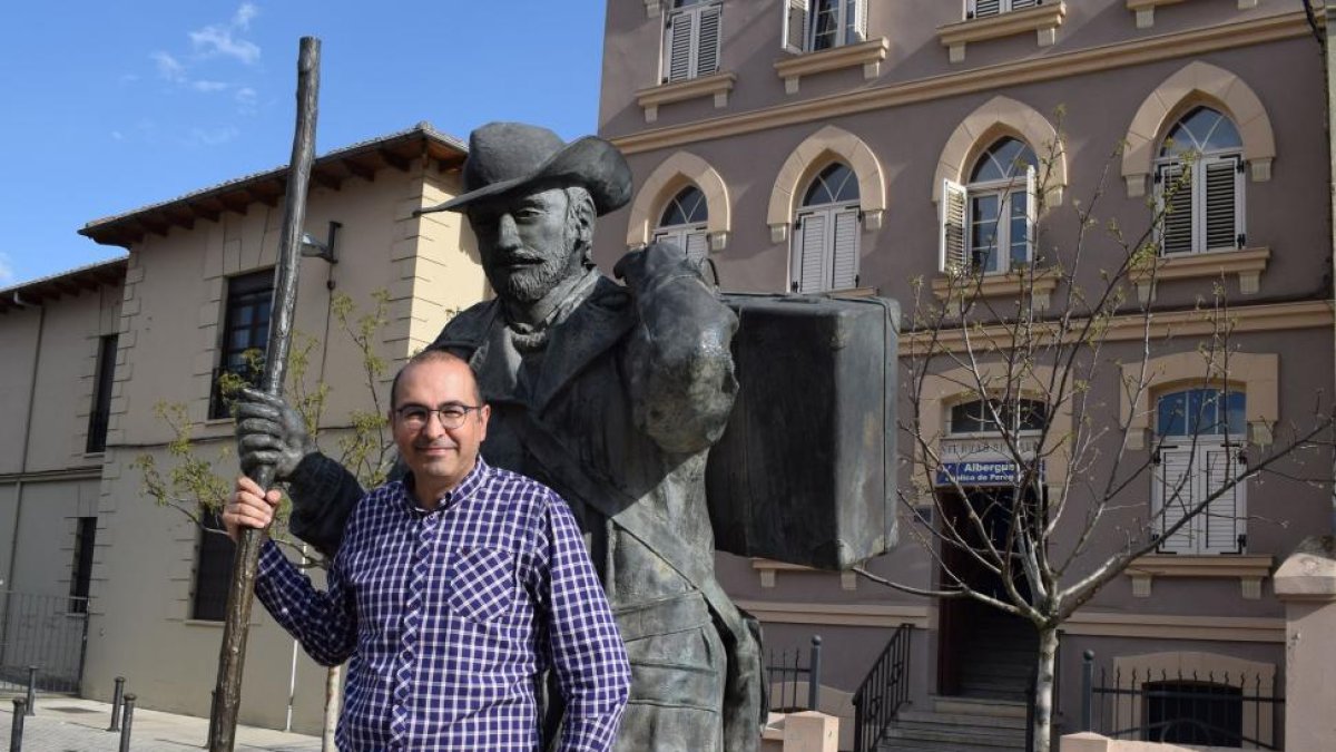 Juan Carlos Pérez, junto a la escultura del peregrino, situada en la Plaza de San Francisco de Astorga, que está delante el albergue de la Asociación de Amigos del Camino de Santiago de Astorga y su Comarca.-ARGI