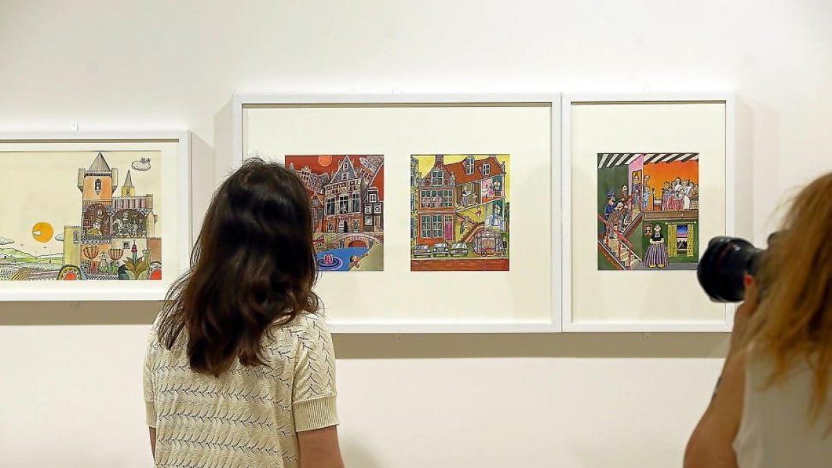 Dos mujeres contemplan varias de las ilustraciones del salmantino Luis de Horna.-MIRIAM CHACÓN / ICAL