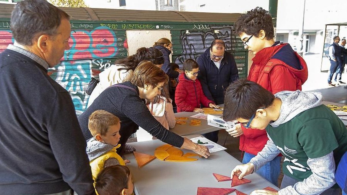 Una familia atiende a uno de los retos propuestos por los alumnos de ESTALMAT.-J.M. LOSTAU