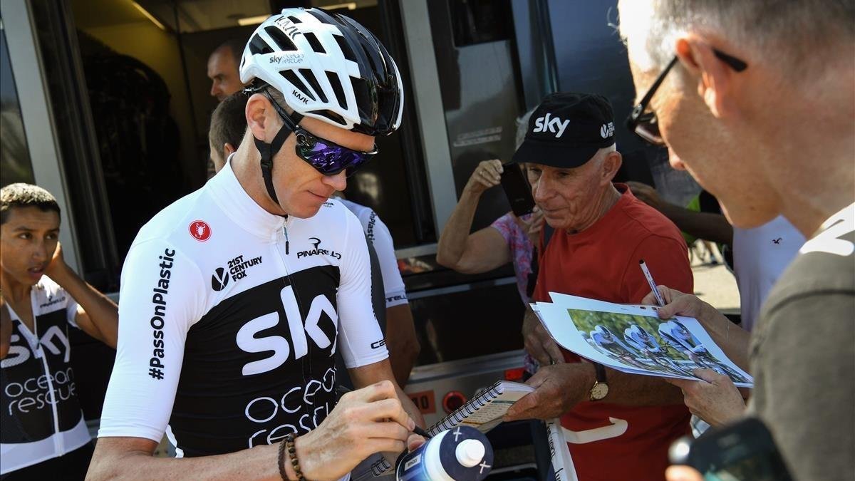 Chris Froome atiende a un aficionado, a las puertas de su hotel en Chambery.-JEAN-PIERRE CLATOT