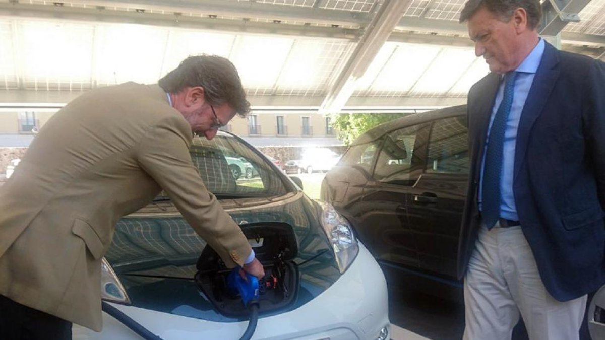 José Luis Vázquez recargando ayer un vehículo eléctrico en presencia de Francisco Vázquez.-TERESA SANZ