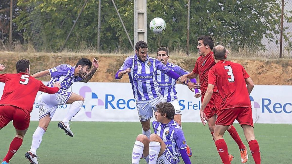 Higinio (centro) cabecea ante la presencia de varios jugadores.-P. REQUEJO